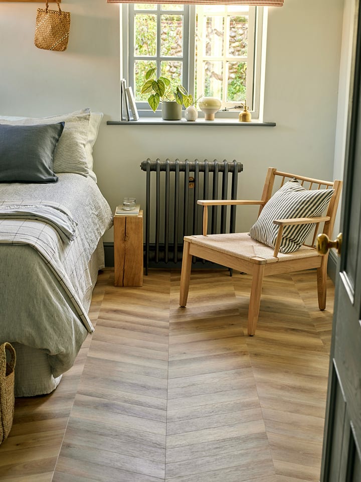 Bedroom floor features Buxton Oak in a Chevron laying pattern with rustic wood furniture.
