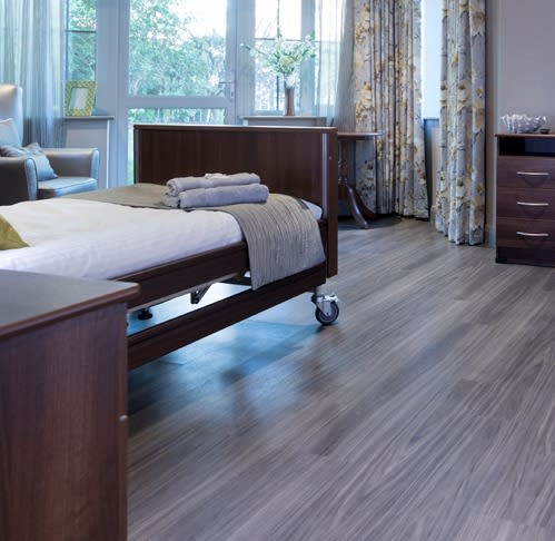 Brown-grey wood-effect floor planks in a care home room