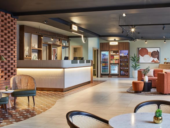 A contemporary hotel reception with Amtico's Decor Classic Goldstone and Amtico's Signature Coombe Stone.