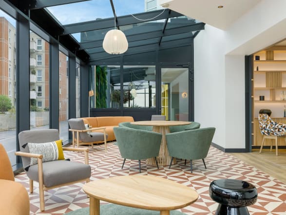The hotel seating area features Gatsby Square Small in Stria Sediment and Encaustic Jasper.