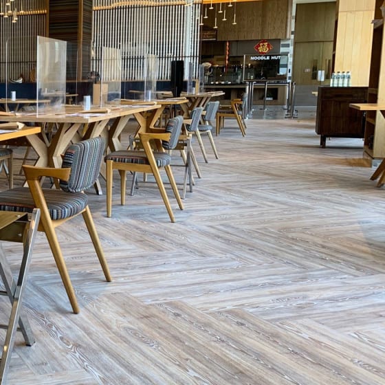 Striking worn ash herrinbone flooring in a hotel restaurant