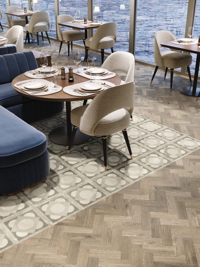 Dining area onboard a ship with oak parquet and Corinithian design flooring in neutral tones