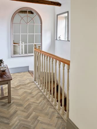 Wood-effect flooring planks in a parquet laying pattern on a home landing