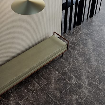 Dark grey and white marbled flooring with white borders around each rectangular tile