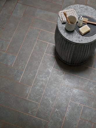 Grey burnished metal effect rectangular floor tiles with copper borders around each tile