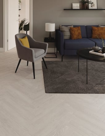 Light-coloured wood-effect floor tiles in parquet laying pattern in a lounge