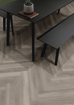 Cool silver-toned wood-effect floor planks in parquet laying pattern with a black table and bench