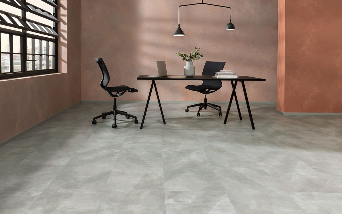 Multitonal grey concrete-effect floor times in a stylish office