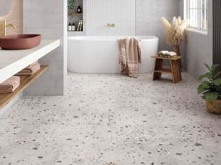 Floor tiles with earth-toned chips on a concrete base in a bathroom