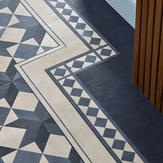 Close up of white and blue patterned floor tiles with a border around the edge