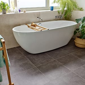Large grey stone-effect square tiles in a bathroom