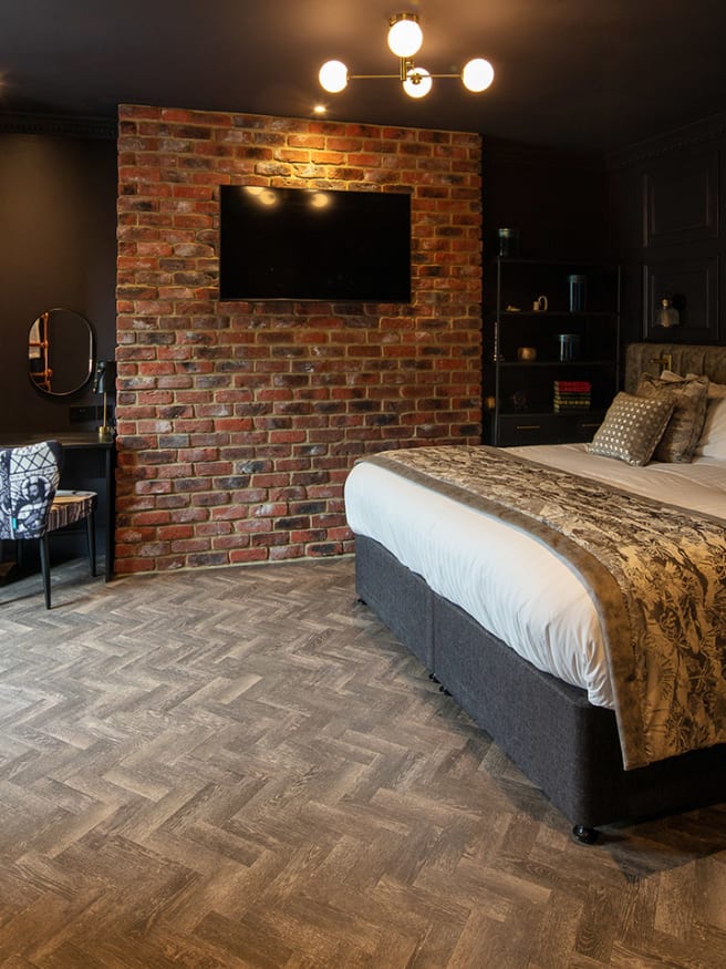 The bedroom features Aspen Oak in a Small Parquet laying pattern.