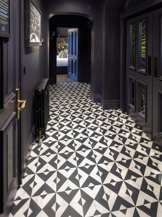 Hallway features dark blue painted walls and doors, with a geometric floor pattern.